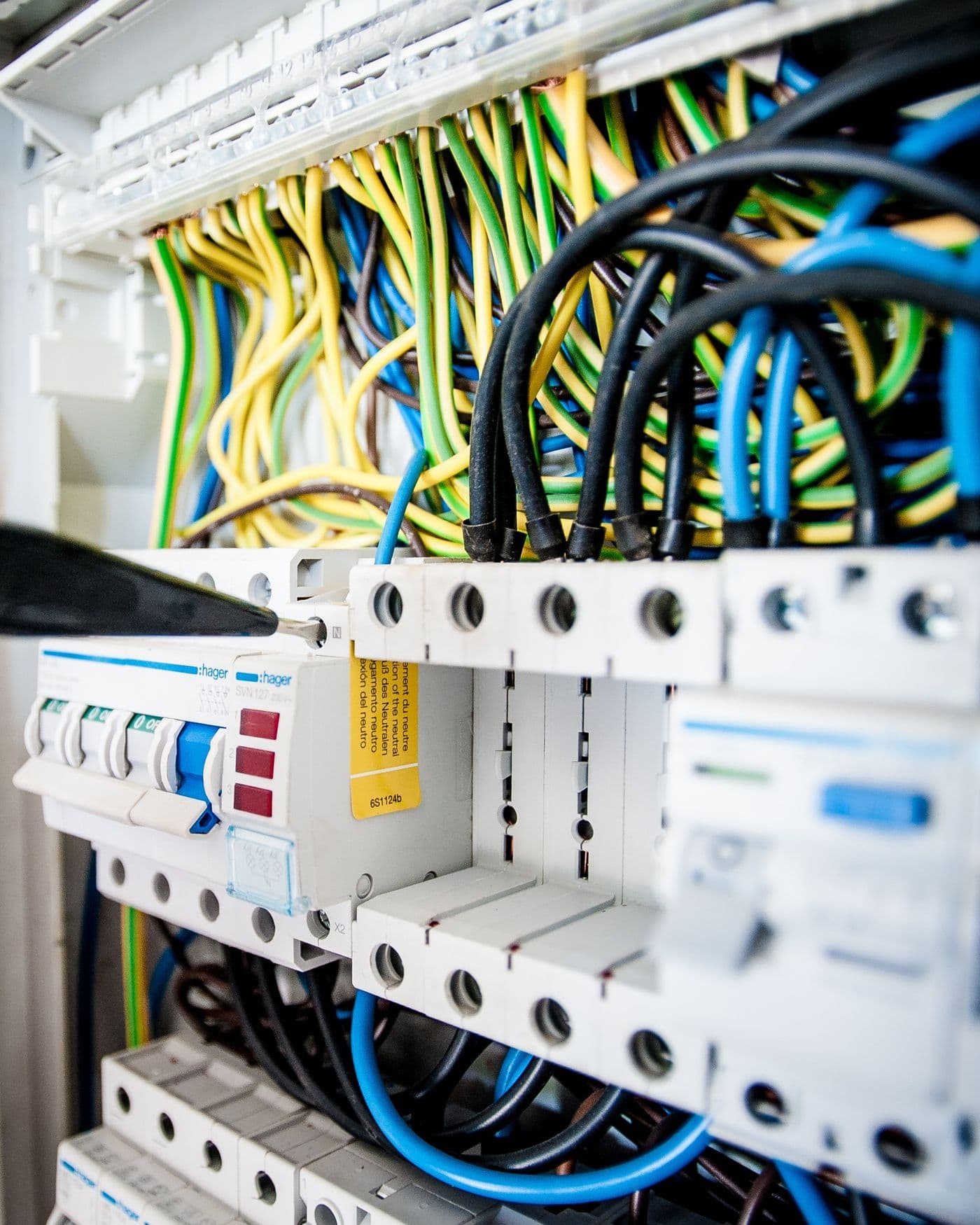 Electrician working on a consumer unit with colour-coded wiring